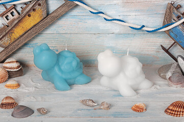 Colorful candle of various shapes on wooden background. Scented candle. Candle with glass. Eggs, sea, heart, flower, fish, starfish, shell, coral, angel. Gift for Christmas, Easter, Valentine's Day.