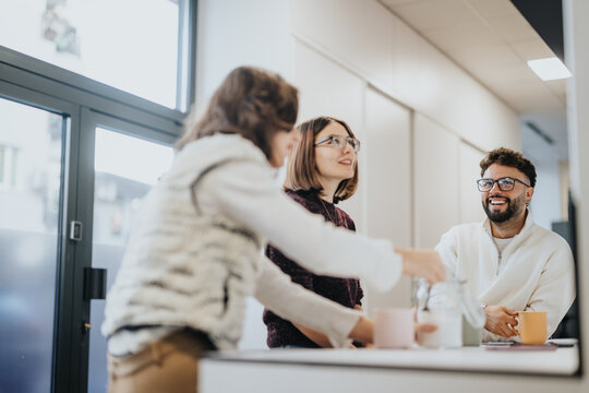 Company employees discussing topics over morning coffee and tea, taking a break from work to relax and have a conversation.