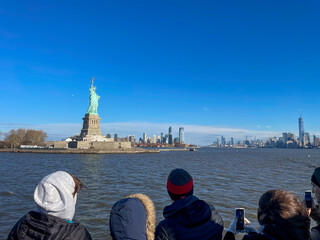 New York, New York – January 11, 2024: the view of the Statue of Liberty from the ferry boat with tourists © HunYoung