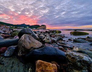 Colorful Sunset and rocks at low tide on the colorful and rocky shoreline on the Gaspe Peninsula on...