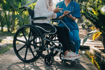 Fototapeta na wymiar nurse with elderly man in wheelchair at park