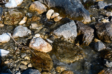 A mountain stream flows between stones. View from above