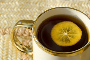 Beautiful mug with gold edging on a knitted background.