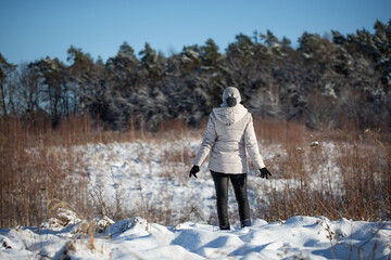Młoda kobieta spacerująca zimą po górskim szlaku śnieżnym	 - obrazy, fototapety, plakaty