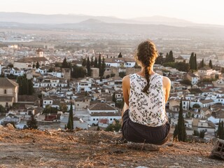Fototapeta na wymiar Young beautiful caucasian woman solo traveller looking at the sunset view in Granada, Andalusia, Spain