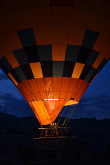 A hot air balloon with people rises into the sky at night