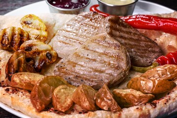 Delicious juicy chicken steak with baked potatoes, mushrooms and sauces