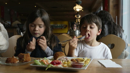 Kids eating food at diner, children enjoying cozy restaurant, siblings little brother and sister