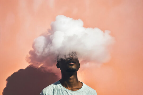 An evocative portrait of a person with a cloud obscuring their head, with sunset hues in the background