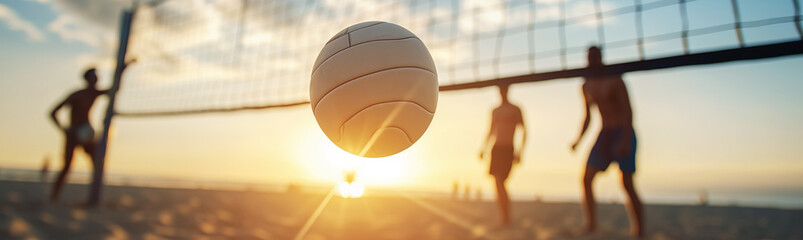 Close-up of a flying volleyball ball on the beach against the backdrop of players and a volleyball...