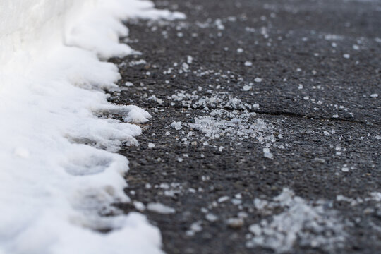 Close up of road with salt for melting snow in winter.