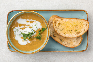 Portion of gourmet restaurant yellow pea soup with toast