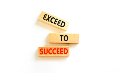 Exceed to succeed symbol. Concept words Exceed to succeed on beautiful wooden blocks. Beautiful white table white background. Business and exceed to succeed concept. Copy space.