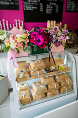 Bouquets in gift boxes and brown boxes for gift wrapping stand in the window