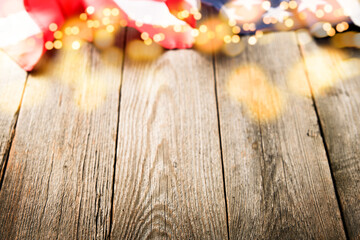 4th of July background. Empty wooden plank table with American USA flag and burning sparkler fireworks and golden lights bokeh. Happy Labor , Independence or Presidents Day. American flag colors.