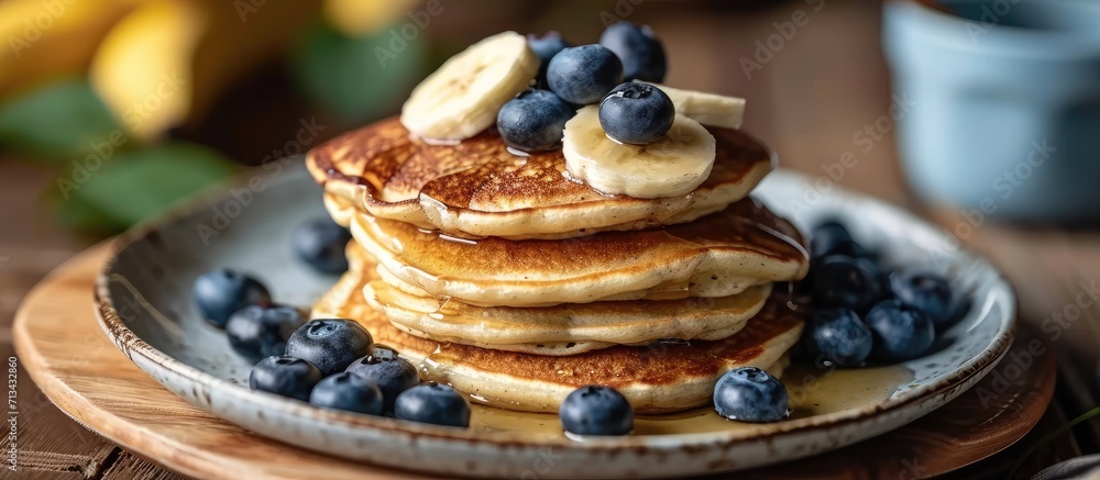 Poster homemade pancakes with syrup and berries morning and breakfast pancakes with banana and blueberries.