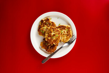  Golden Brown Chopped Chicken Cutlets or Patties with mozzarella cheese on white plate. On red background. Pop art style bright food photo