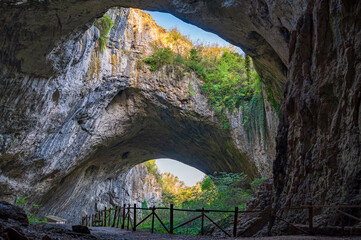 Giant cave with big holes in the sealing, all full of trees and water - Devetashka cave