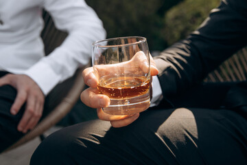 Close-up of hands with clinking whiskey glasses. Cheers mate