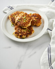  Golden Brown Chopped Chicken Cutlets or Patties with mozzarella cheese on white vintage plate. Minimalistic food photo on white marble background 
