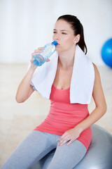 Ball, portrait or woman drinking water on break after exercise, workout or fitness training in gym. Fatigue, tired lady or thirsty sports athlete with liquid bottle for wellness, rest or hydration