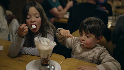 Youthful Joy in Sweet Treat - Young Brother and Sister Savoring Whipped Cream Sundae at Local Diner...
