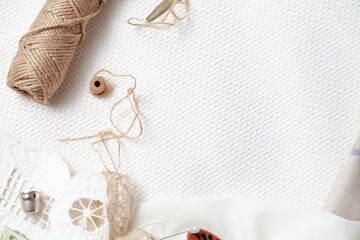 Coil of rope and steel thimble lie on white cloth.... - obrazy, fototapety, plakaty