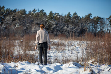 Young woman walking on a mountain snow trail in winter