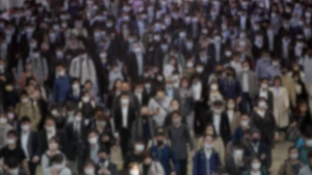 Timelapse of blurred defocused view of Japanese pedestrians. Aerial view of high concentration of people. The city is known for its efficient and orderly pedestrian traffic flow.