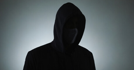 A silhouette of a faceless man in a dark profile, hiding his identity with a mysterious mask.