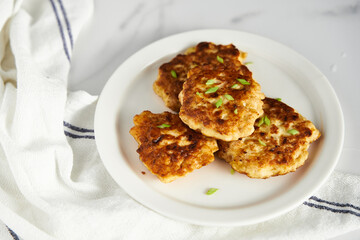  Golden Brown Chopped Chicken Cutlets or Patties with mozzarella cheese on white vintage plate. Minimalistic food photo on white marble background 