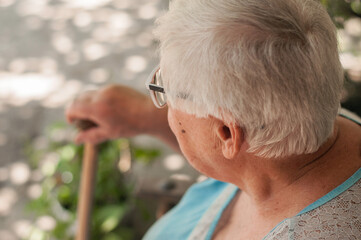 Senior grey haired woman sitting on bench outdoors