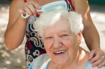 elderly senior woman having her hair combed