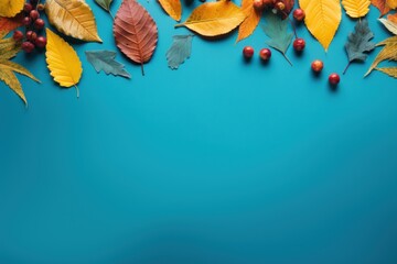  autumn leaves and berries on a blue background with copy - space for a text or an image or a clipping.