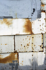 Vintage background of different old metal sheets fastened together with nails and rivets. Texture of rust and cracked paint on a metal surface.
