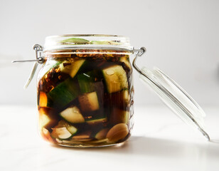 Preserved and marinated cucumbers in jars in asian or Chinese style with soy sauce, garlic. Also...