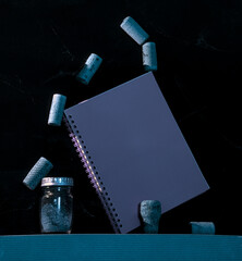 unlikely balance (corks, book, black background) - obrazy, fototapety, plakaty