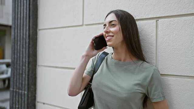 Young beautiful hispanic woman smiling confident talking on the smartphone at street