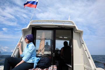 A girl sails on a white boat on the Pacific Ocean, the flag flutters, Kamchatka, rest.