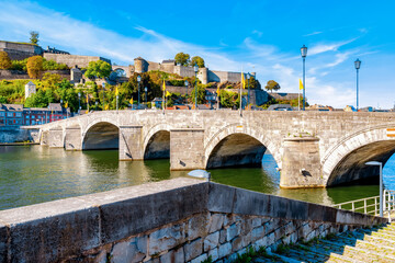 Obraz premium The stone arches of the bridge of Jambes over the Meuse at the foot of the hill of the Citadel of Namur, Belgium