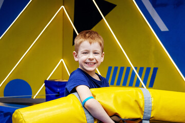 the battle of soft weapons on trampolines. A red-haired boy holds a whipping pillow