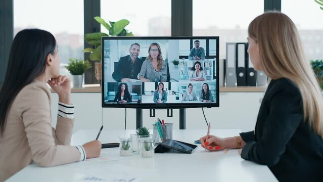 Video of smart business people doing a video call with working colleagues in a coworking place