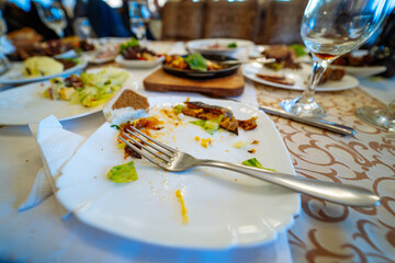 White Plate Topped With Food Next to Glass of Wine. A picturesque white plate full of delectable...