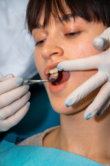 Woman Getting Teeth Checked by Dentist for Stomatolia, Dental Treatment. A woman visits the dentist...