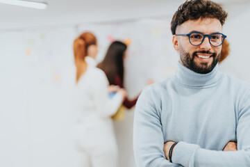 Obraz premium Businessman posing at the office with crossed hands and smile on his face. Copy space.