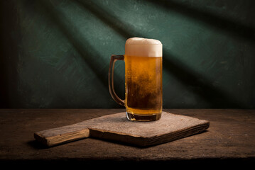 mug of beer, wheat ears, hops and beer barrel on a wooden background. High quality photo