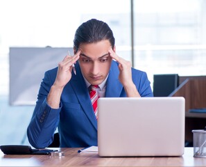 Young handsome businessman sitting in the office