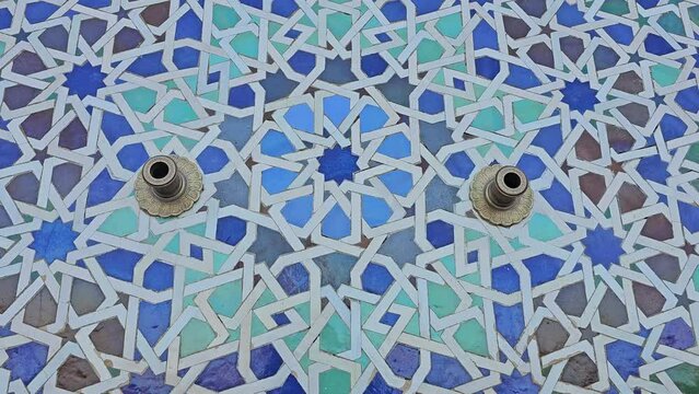 pan shot on Moroccan Colorful zellige tiles pattern at the Mohammed V mausoleum in Rabat Morocco . Mosaic pattern, traditional Islamic geometric design. Moroccan craft, handmade.
