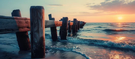  beautiful sunset at the wooden jetty at the beach. Copy space image. Place for adding text or design © Gular