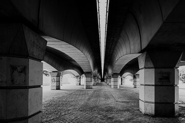 Pedestrian area underneath the solid bridge construction in black and white